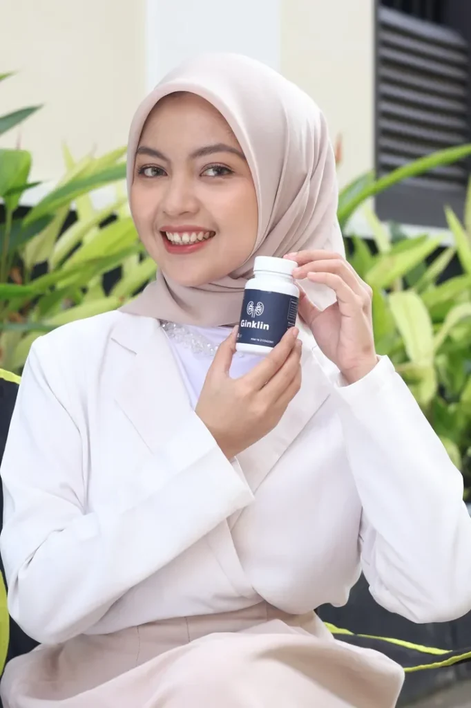 Perempuan berhijab memegang botol Ginklin